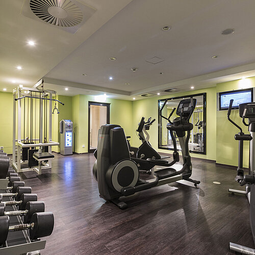 Moderner Fitnessraum im Maritim Hotel Königswinter mit Laufbändern, Hanteln und Trainingsgeräten.