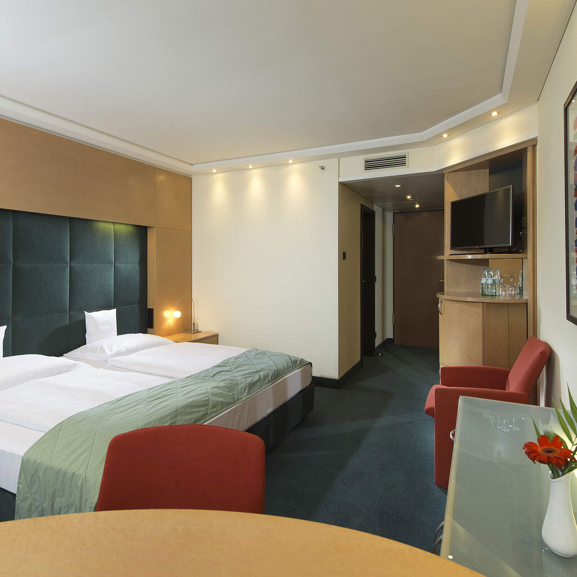 Comfort Zimmer Komfort-Zimmer im Maritim proArte Hotel Berlin, ausgestattet mit modernen Möbeln, Doppelbett, Kunstwerk und Schreibtisch.