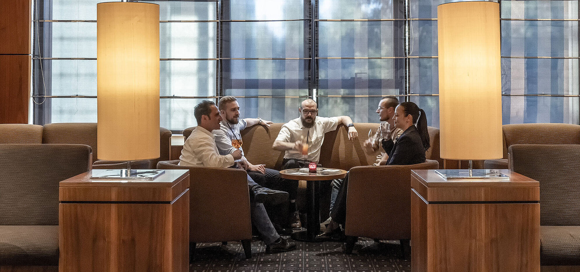 Gemütliche Sitzbereiche in der Hotelbar des Maritim Hotel Düsseldorf mit moderner Beleuchtung und Gästen im Gespräch.
