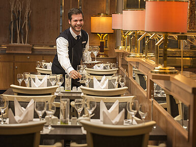 Servicekraft mit Tablett voller Gläser im Restaurant des Maritim Hotel Stuttgart, freundlich und einladend