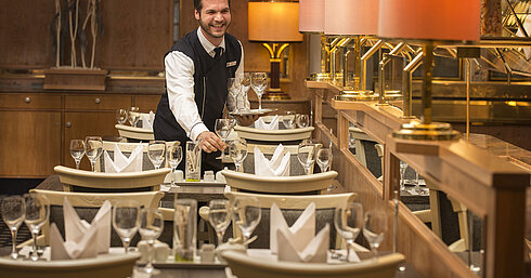 Servicekraft mit Tablett voller Gläser im Restaurant des Maritim Hotel Stuttgart, freundlich und einladend