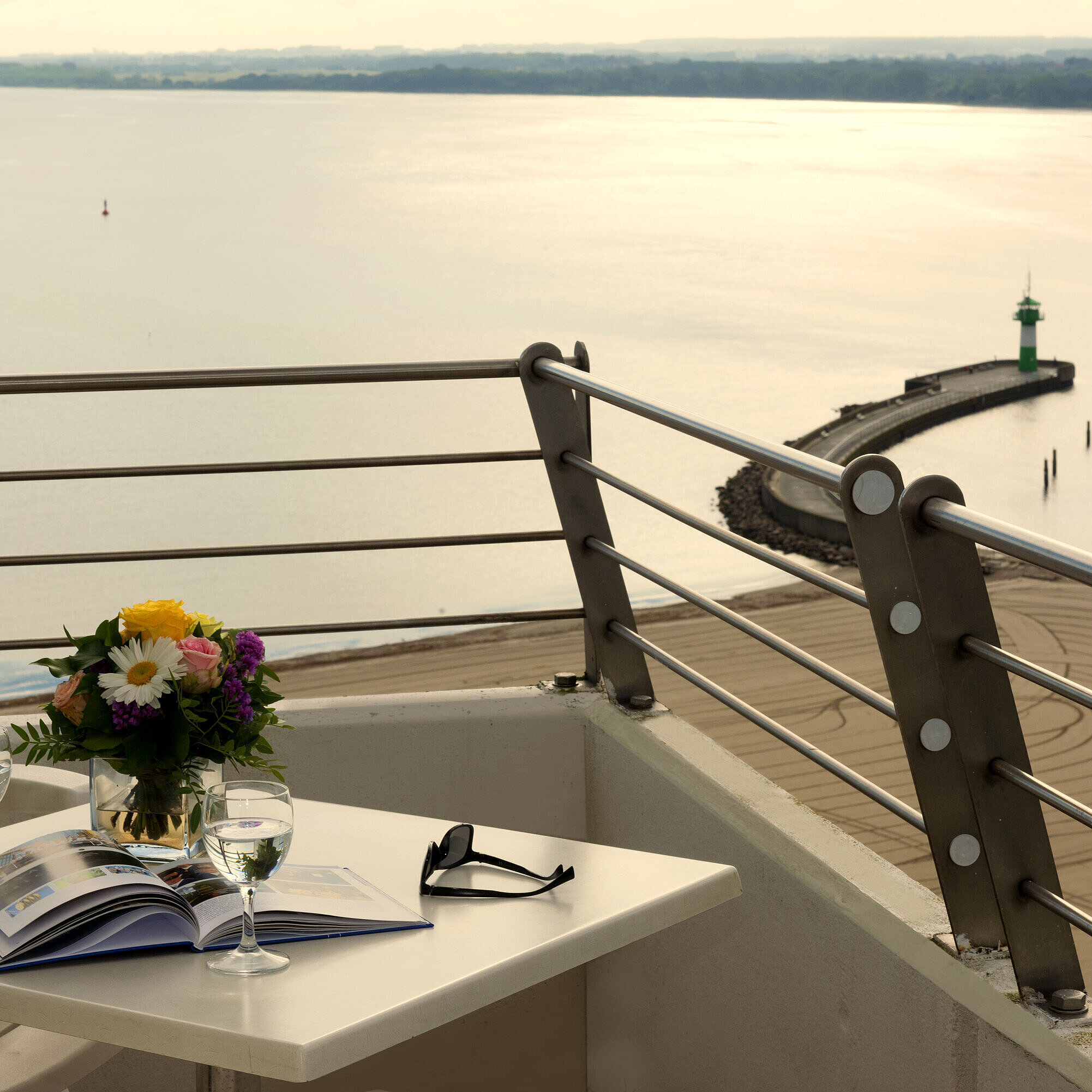 Suite Balkon mit Meerblick Balkon mit Meerblick im Maritim Hotel Travemünde, gedeckter Tisch mit Wein und Blumen