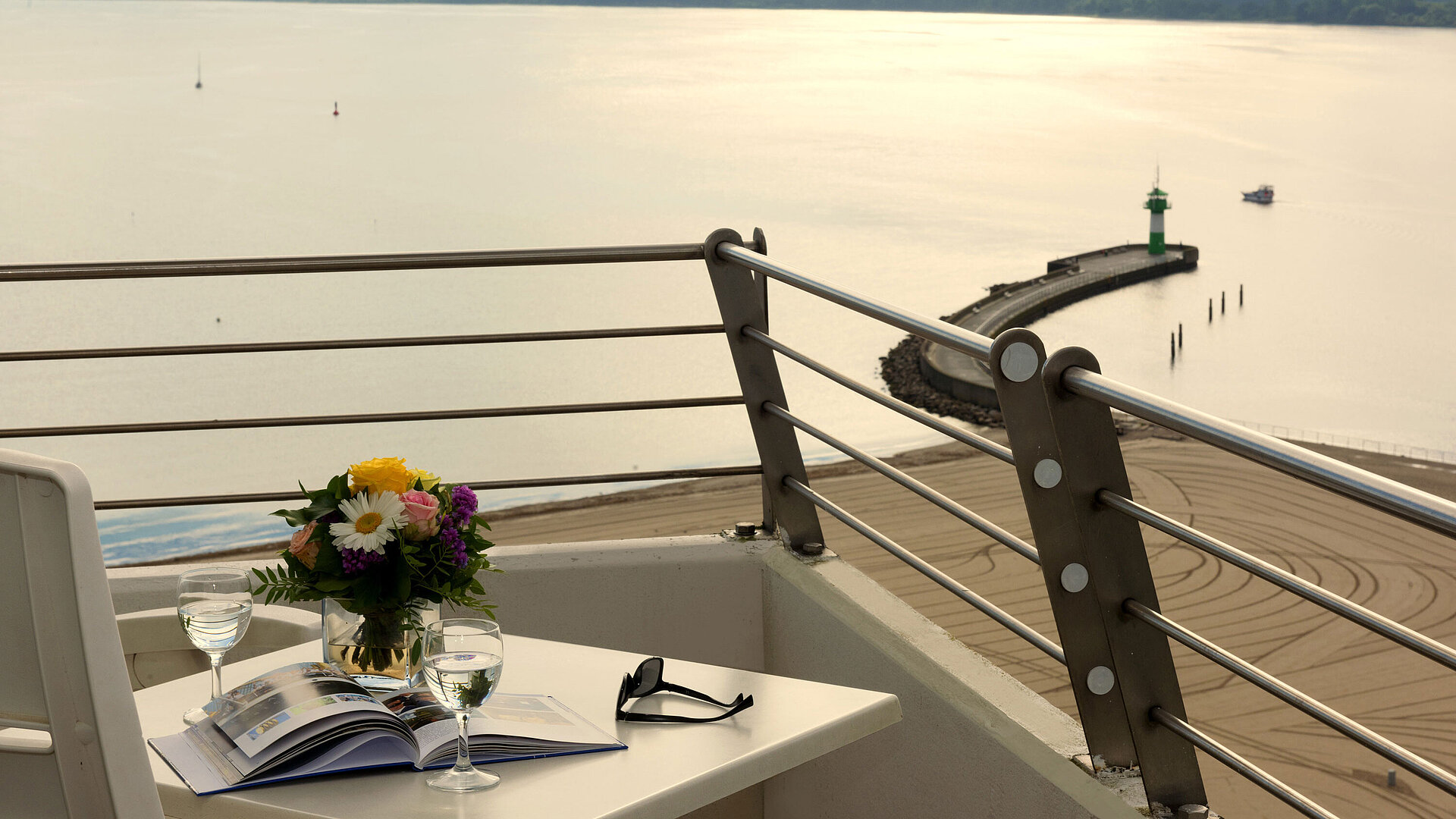 Suite Balkon mit Meerblick Balkon mit Meerblick im Maritim Hotel Travemünde, gedeckter Tisch mit Wein und Blumen