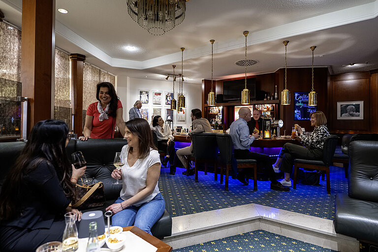 Gäste genießen Drinks in der stilvollen Bar des Maritim Hotel Bad Homburg mit entspannter Atmosphäre und warmem Ambiente.