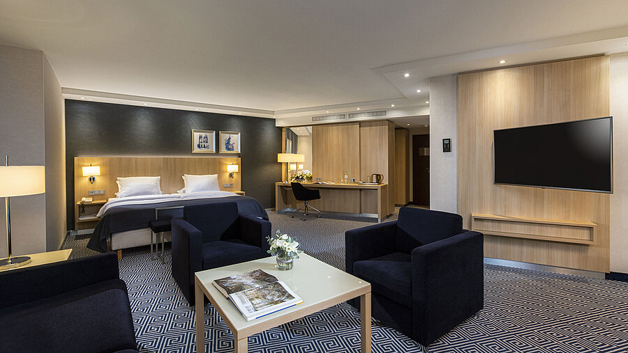 Geräumige Junior Suite im Maritim Hotel Würzburg mit Doppelbett und gemütlicher Sitzecke