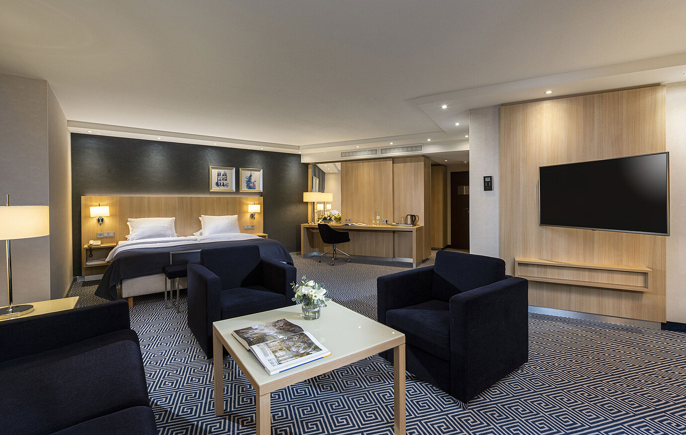 Geräumige Junior Suite im Maritim Hotel Würzburg mit Doppelbett und gemütlicher Sitzecke
