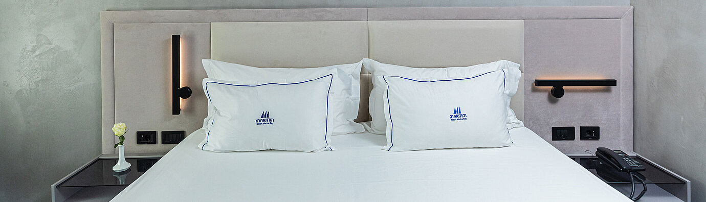 Modernes Doppelbett im Maritim Resort Marina Bay mit stilvollem Kopfteil und Kissen