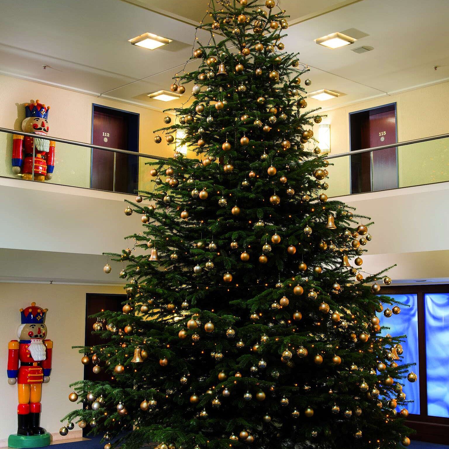 Festlicher Weihnachtsbaum im Foyer mit Geschenken.