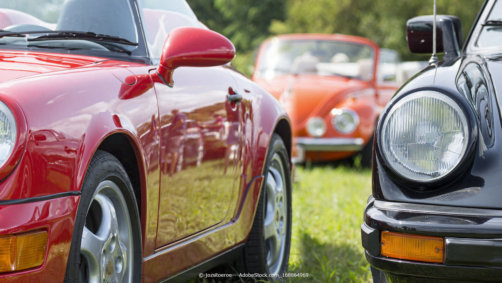 Klassische Oldtimer-Sportwagen Klassische Oldtimer-Sportwagen nebeneinander auf einer Wiese bei einem Oldtimer-Treffen