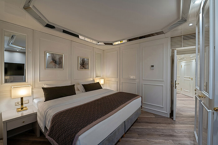 Suite Schlafbereich eines Hotelzimmers mit Doppelbett, Nachttischen, warmem Licht und klassischer Einrichtung.