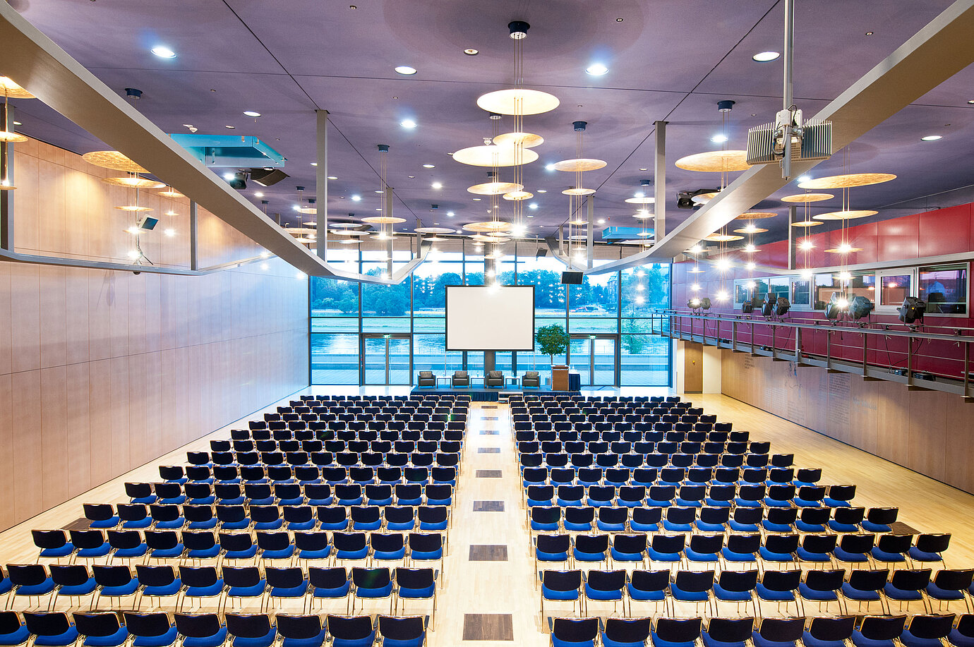 Großer Konferenzsaal im Maritim Hotel Dresden mit Reihen blauer Stühle und Blick auf die Elbe.