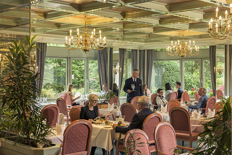 Großes Restaurant im Maritim Hotel Bad Salzuflen mit Kronleuchtern, Fensterfront und eleganter Atmosphäre