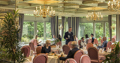 Großes Restaurant im Maritim Hotel Bad Salzuflen mit Kronleuchtern, Fensterfront und eleganter Atmosphäre