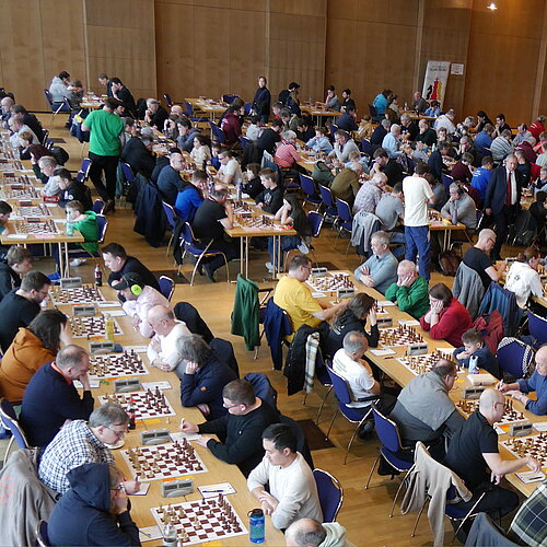 Große Schach-Amateurmeisterschaft mit zahlreichen Spielern in einer Turnierhalle