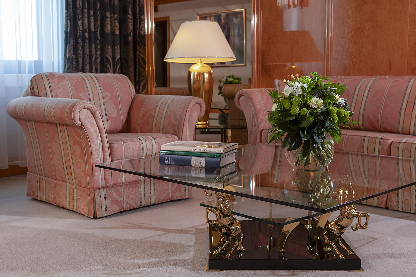 Stilvolles Wohnzimmer im Maritim Hotel Hannover mit eleganter Sitzgruppe und Glas-Couchtisch.