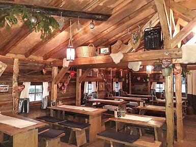 *Gemütlicher Gastraum mit Holztischen und Almhütten-Deko in der Maritim Alm beim Maritim Hotel Stuttgart*