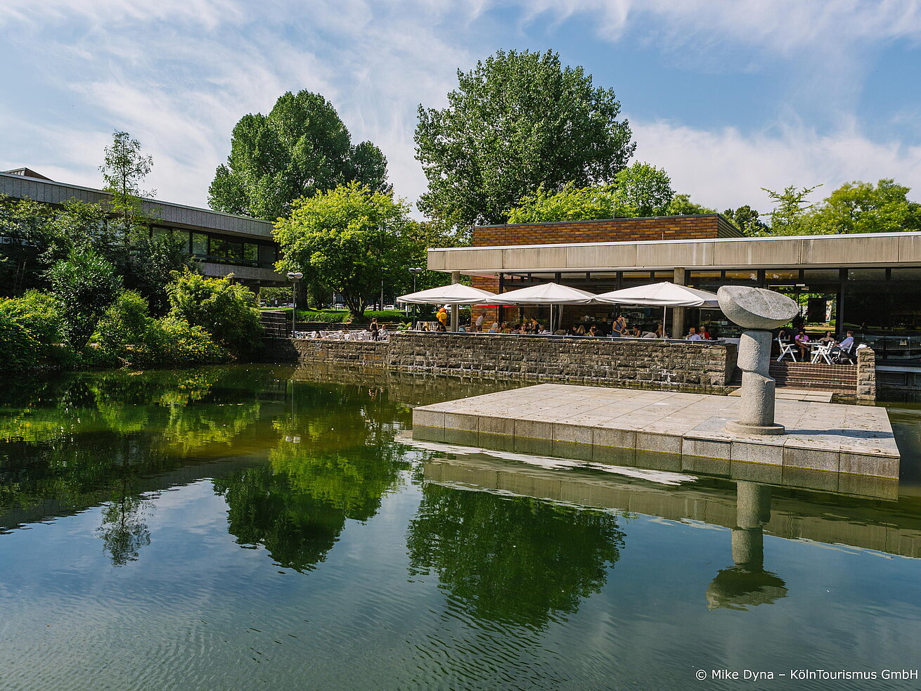 Museum für ostasiatische Kunst Restaurant Terrasse am Wasser mit Gästen und grüner Parkanlage in Köln
