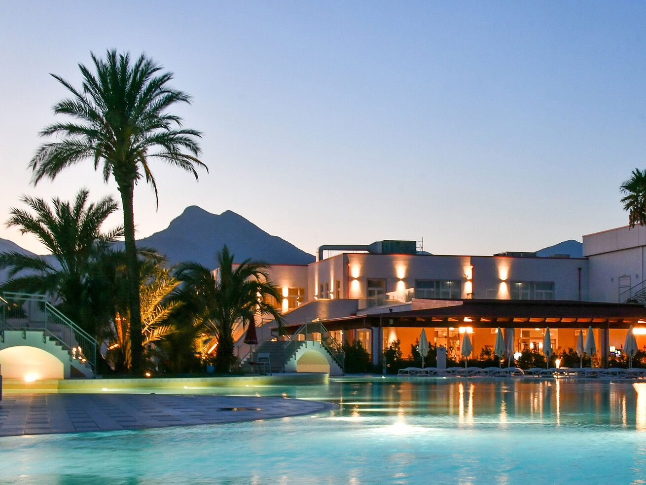 Pool Poolbeleuchtung am Abend im Maritim Resort Calabria mit Palmen und Gebirgskulisse