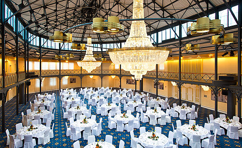 Großer Bankettsaal mit runden, festlich gedeckten Tischen und beeindruckenden Kronleuchtern im Maritim Hotel Stuttgart