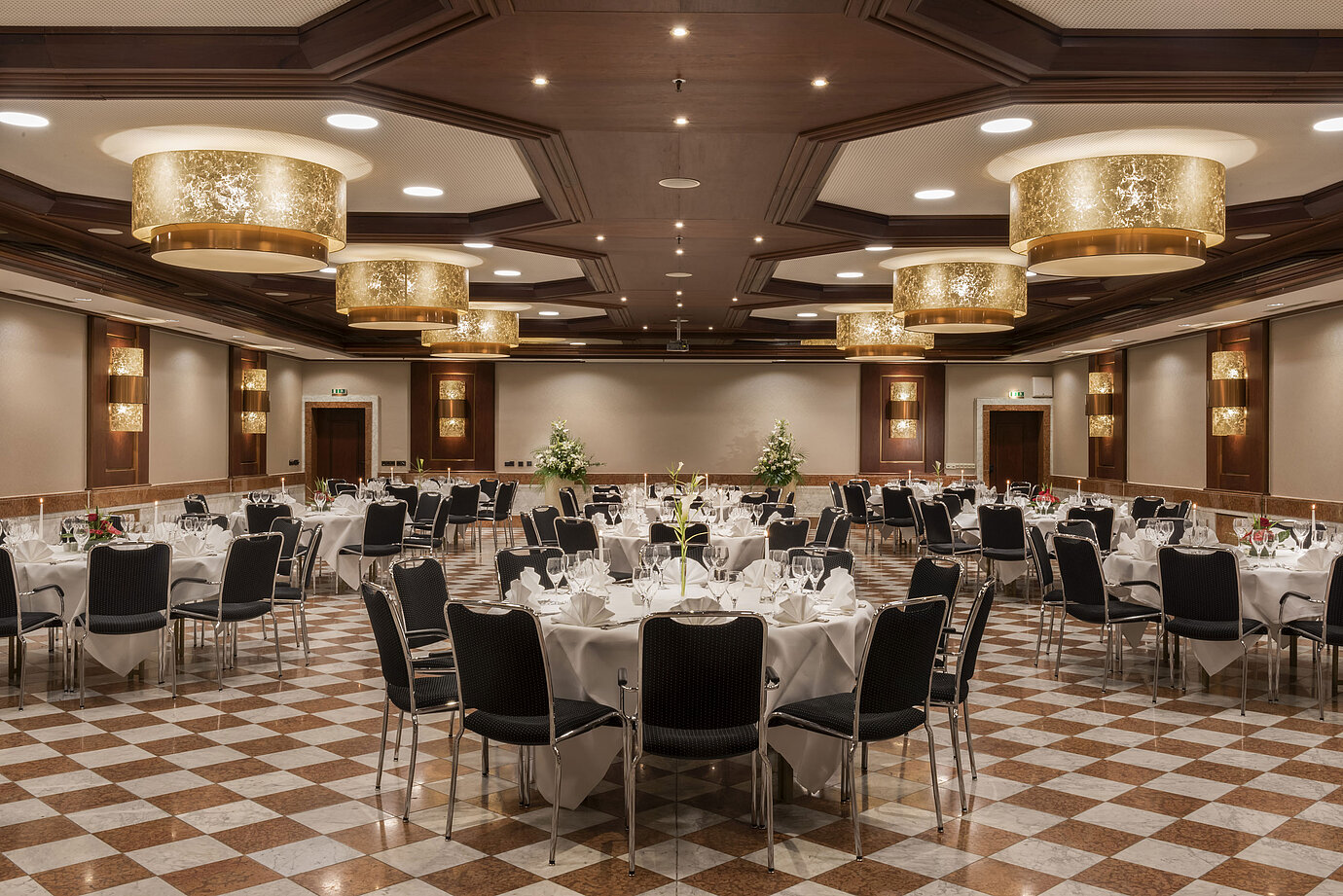 Eleganter Festsaal im Maritim Hotel Königswinter mit runden Tischen, stilvoller Dekoration und Kronleuchtern.