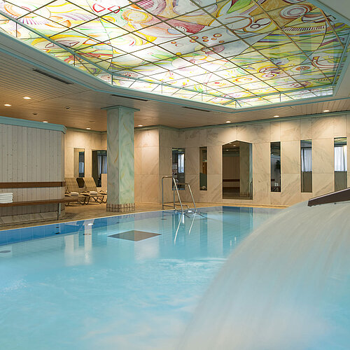 Beheizter Innenpool mit Wasserfall und bunter Glasdecke im Maritim Hotel Stuttgart