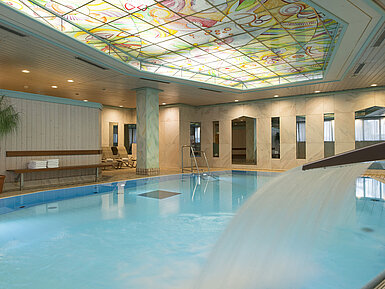 Beheizter Innenpool mit Wasserfall und bunter Glasdecke im Maritim Hotel Stuttgart