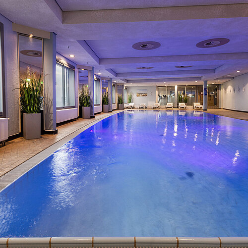 Beleuchteter Indoor-Pool im Maritim Hotel Frankfurt mit entspannter Atmosphäre und Panoramafenstern.