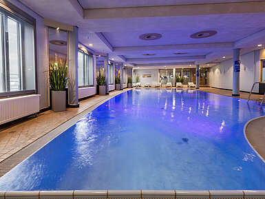 Pool Beleuchteter Indoor-Pool im Maritim Hotel Frankfurt mit entspannter Atmosphäre und Panoramafenstern.