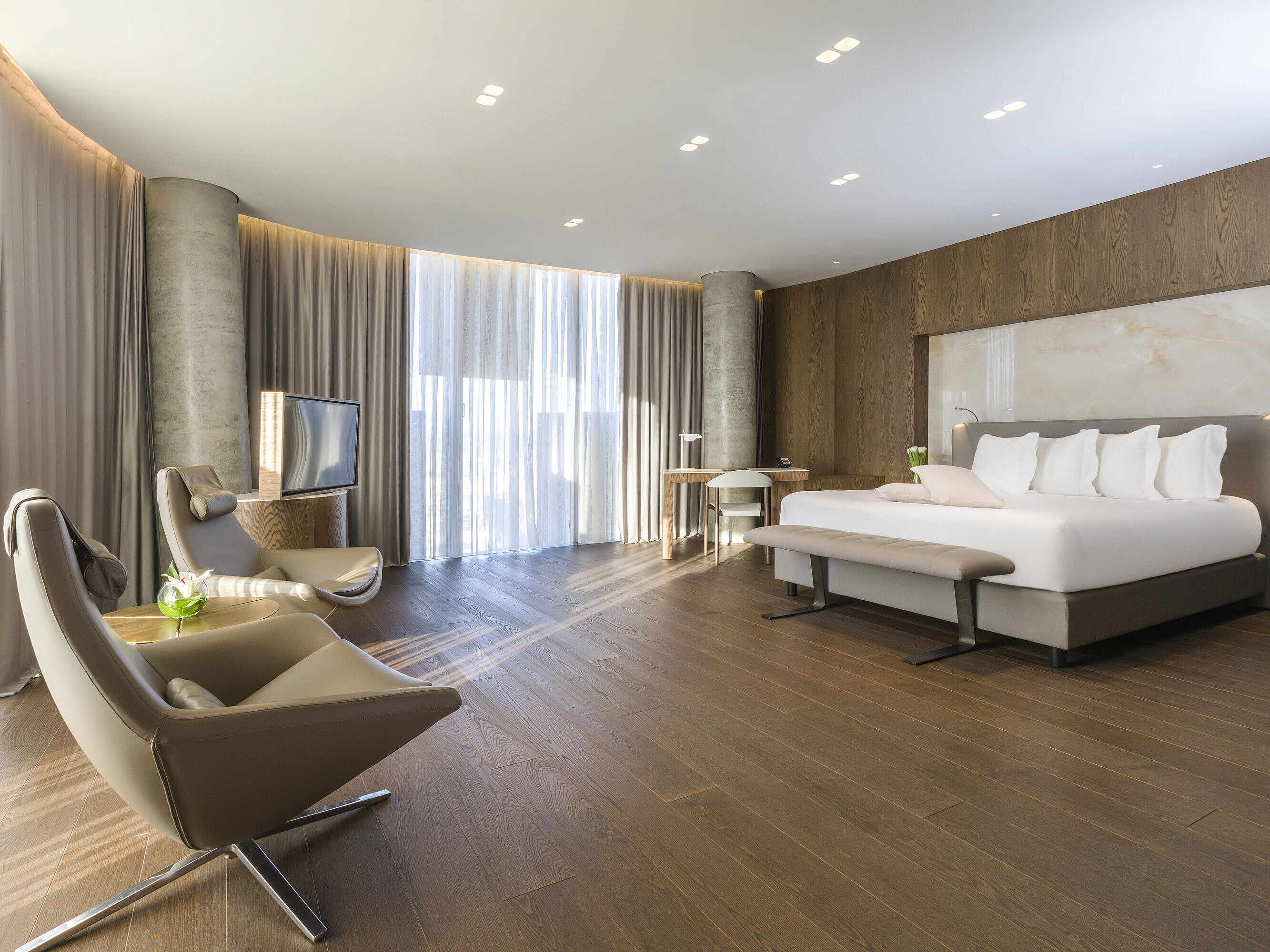 Großzügiges Zimmer mit Panoramafenstern, Sesseln und modernem Design im Maritim Hotel Plaza Tirana
