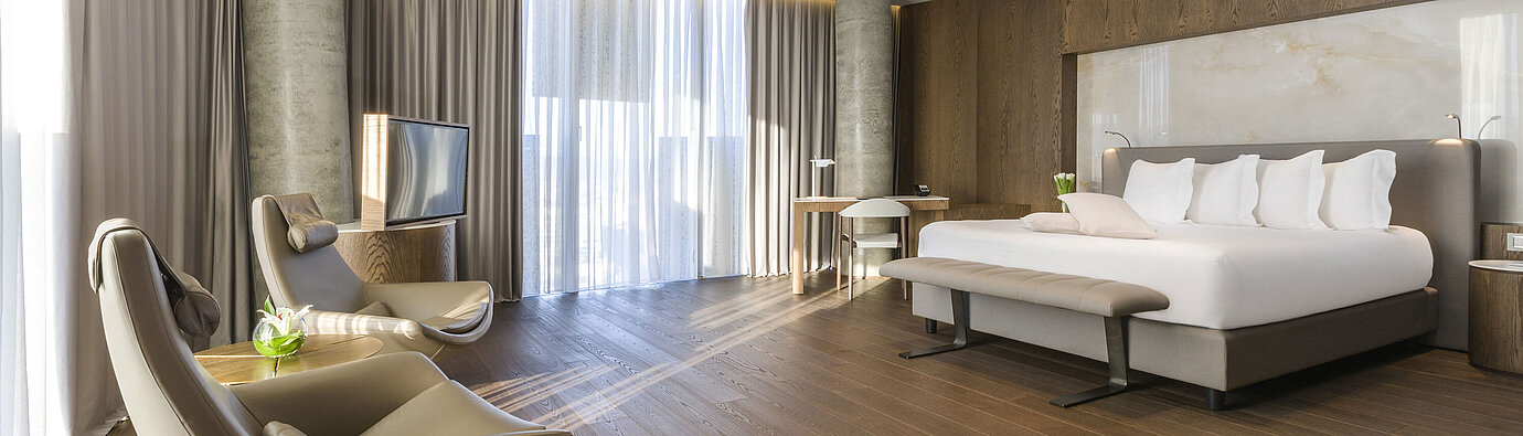 Großzügiges Zimmer mit Panoramafenstern, Sesseln und modernem Design im Maritim Hotel Plaza Tirana