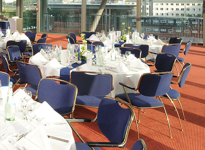  Eleganter Veranstaltungsraum im Maritim Hotel Dresden mit festlich gedeckten Tischen und Blick auf die Stadt.