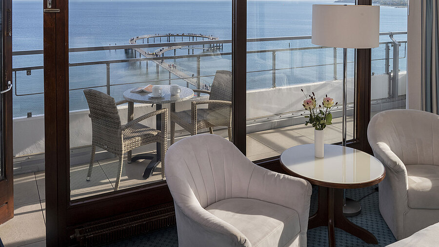 Hotelzimmer mit Sitzbereich und Balkon mit Meerblick im Maritim Seehotel Timmendorfer Strand.