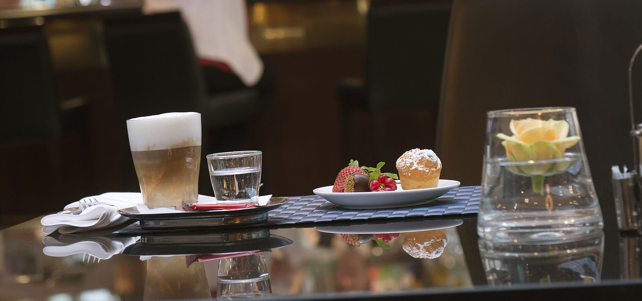Latte Macchiato und Gebäck im Café des Maritim Hotel Stuttgart mit Blick auf die Bar im Hintergrund