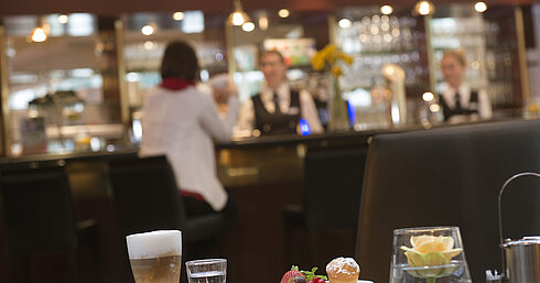 Latte Macchiato und Gebäck im Café des Maritim Hotel Stuttgart mit Blick auf die Bar im Hintergrund