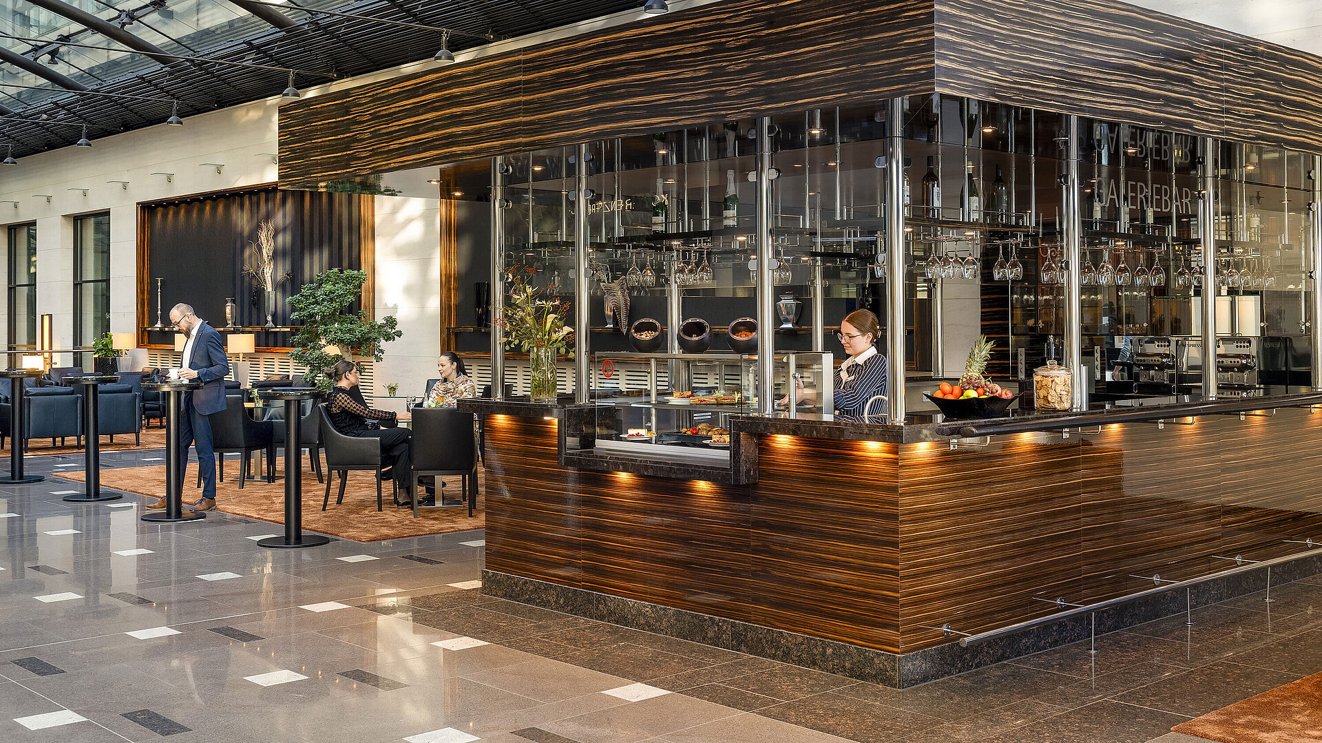 Café Moment Modernes Café im Maritim Hotel Düsseldorf mit eleganter Ausstattung, Sitzbereichen und einer Mitarbeiterin hinter der Theke.