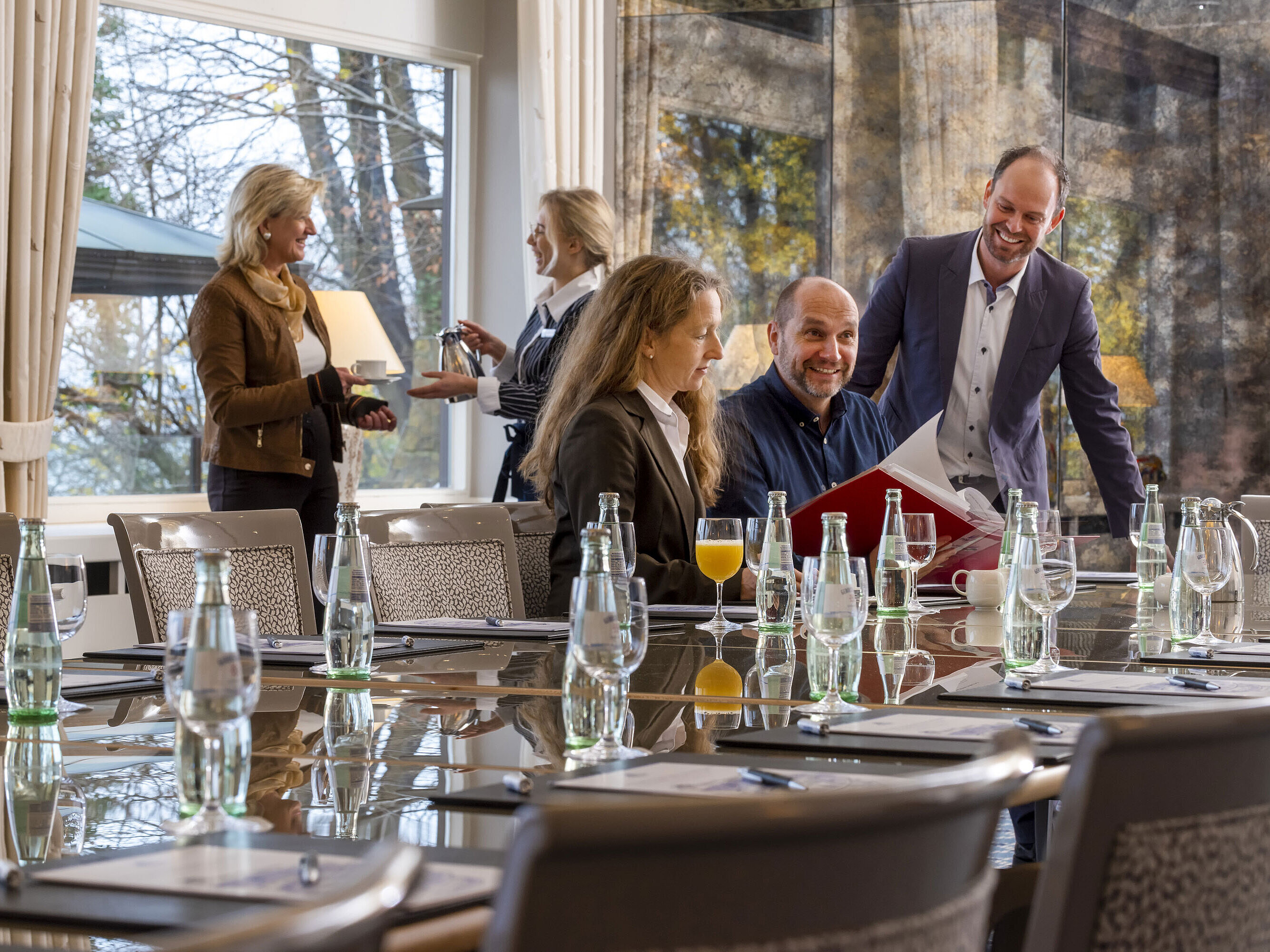 Salon Oslo im Maritim Hotel Kiel, Teilnehmer in einer Besprechung, entspannte Atmosphäre mit Getränken und freundlichem Service.