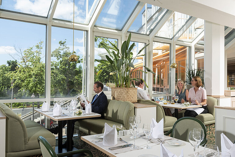 Geräumiges Restaurant im Maritim Hotel Würzburg mit Panoramafenstern und einladender Sitzgruppe