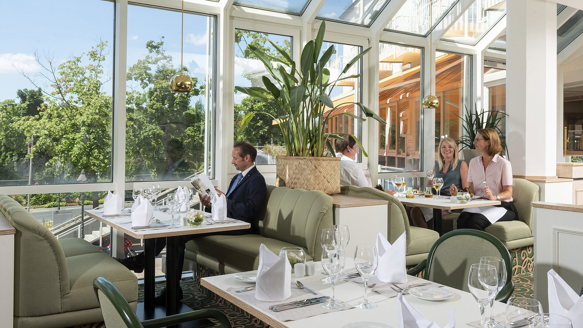 Geräumiges Restaurant im Maritim Hotel Würzburg mit Panoramafenstern und einladender Sitzgruppe