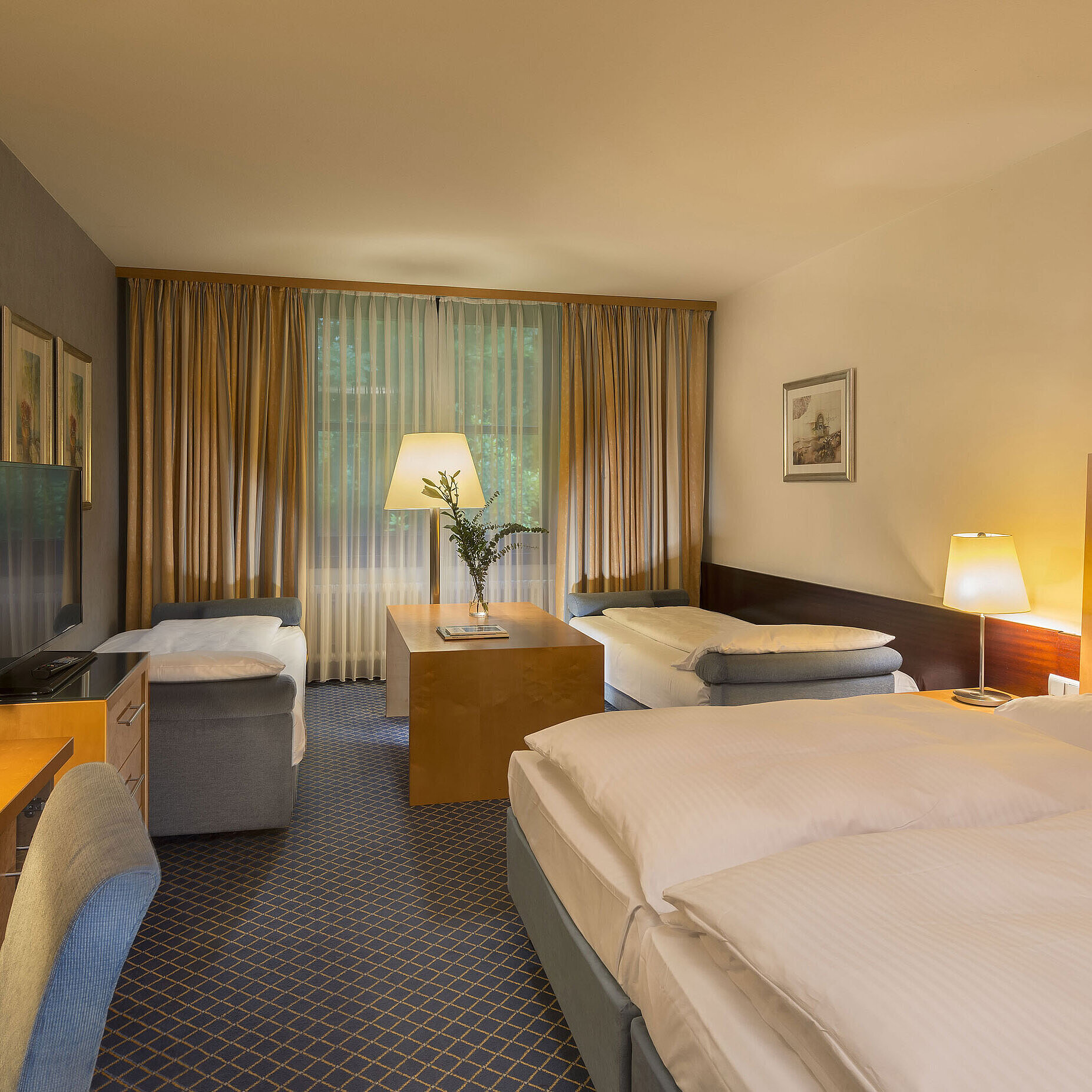 Familienzimmer Geräumiges Familienzimmer im Maritim Hotel Fulda mit vier Betten, Schreibtisch und gemütlicher Atmosphäre.