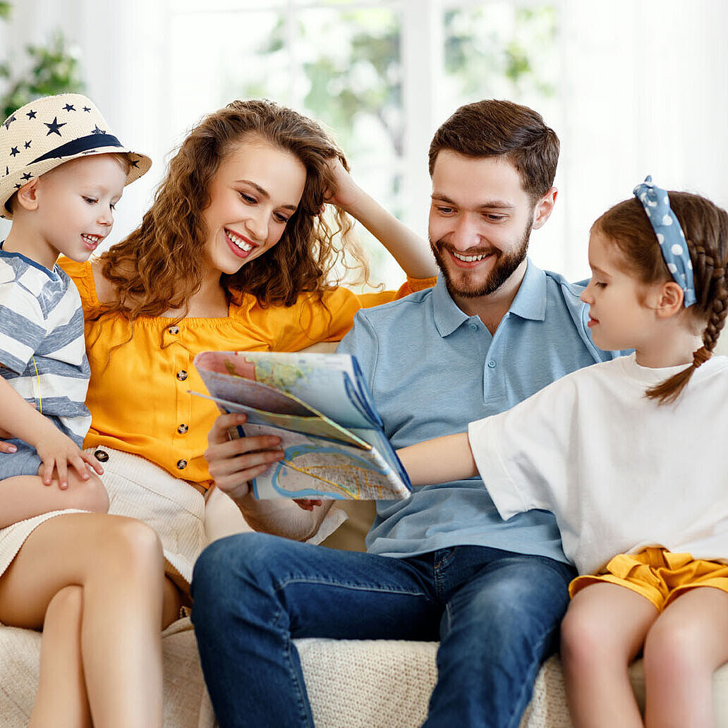 Glückliche Familie plant gemeinsam Urlaub zu Hause