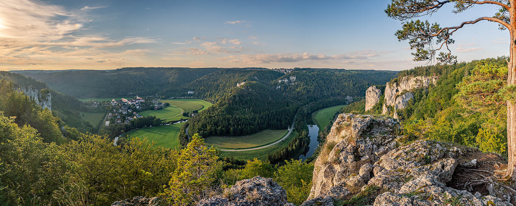 Panorama über das Donautal mit Fluss, grünen Wiesen und steilen Felsen