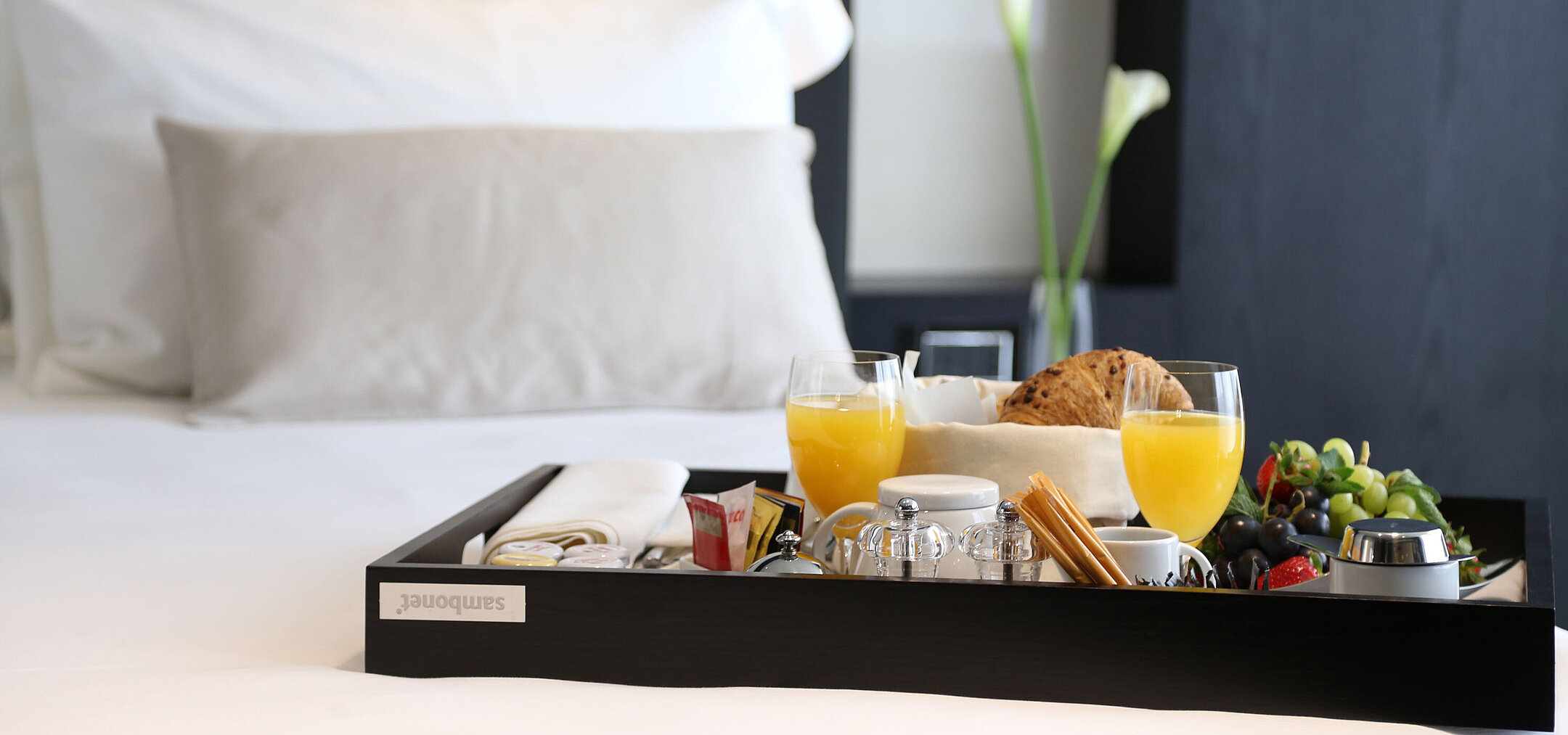 Frühstückstablett mit Saft, Gebäck und Obst auf dem Bett im Maritim Hotel Plaza Tirana