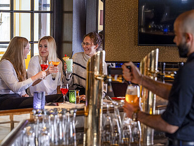 Gäste genießen Cocktails an der Bar des Maritim Hotel Würzburg.