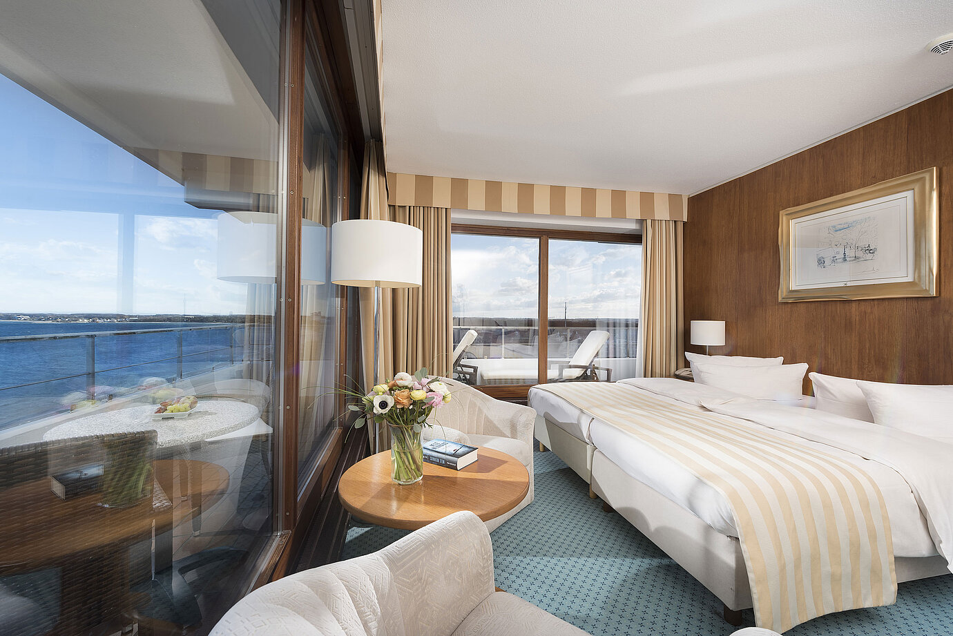 Superior Zimmer im Maritim Seehotel Timmendorfer Strand mit Meerblick, Doppelbett, Sitzecke und Balkon.