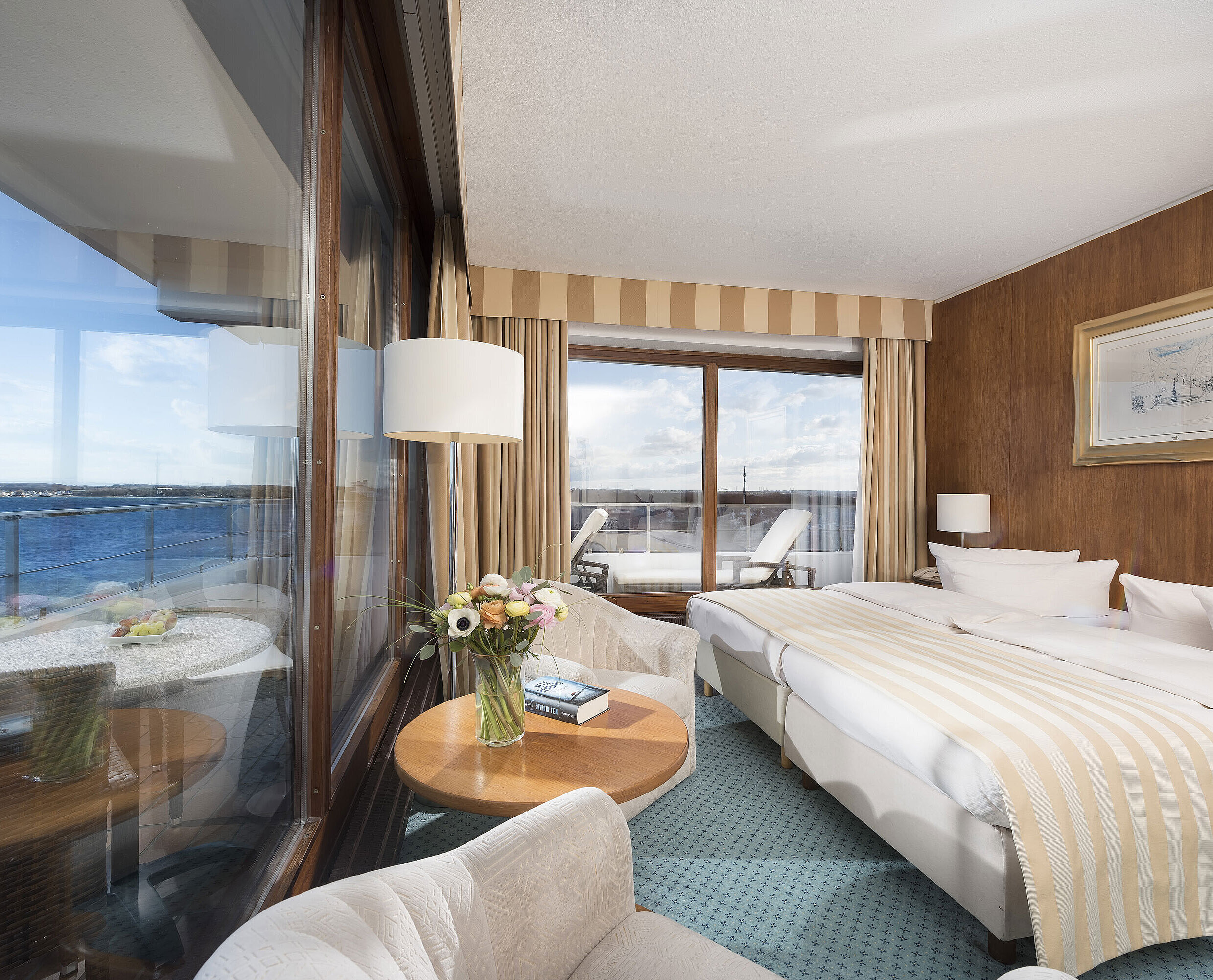 SuperiorPlus Seeseite Superior Zimmer im Maritim Seehotel Timmendorfer Strand mit Meerblick, Doppelbett, Sitzecke und Balkon.