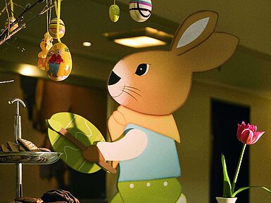 Festlich dekorierter Tisch mit Osterhasen, bunten Eiern und Latte Macchiato im Maritim Hotel Fulda.