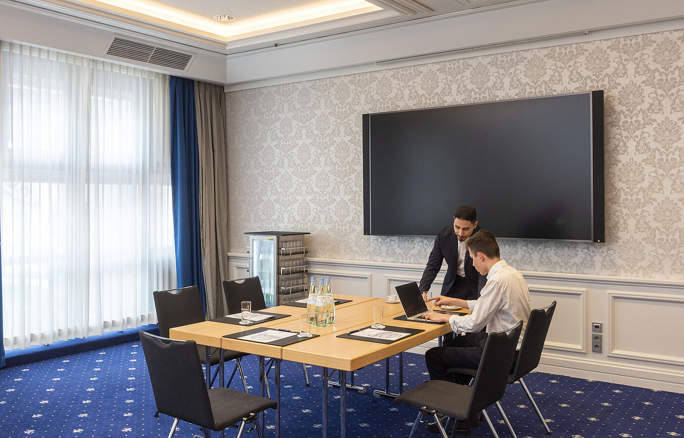 Zwei Personen arbeiten im Salon Oegg des Maritim Hotel Würzburg mit modernem Bildschirm.