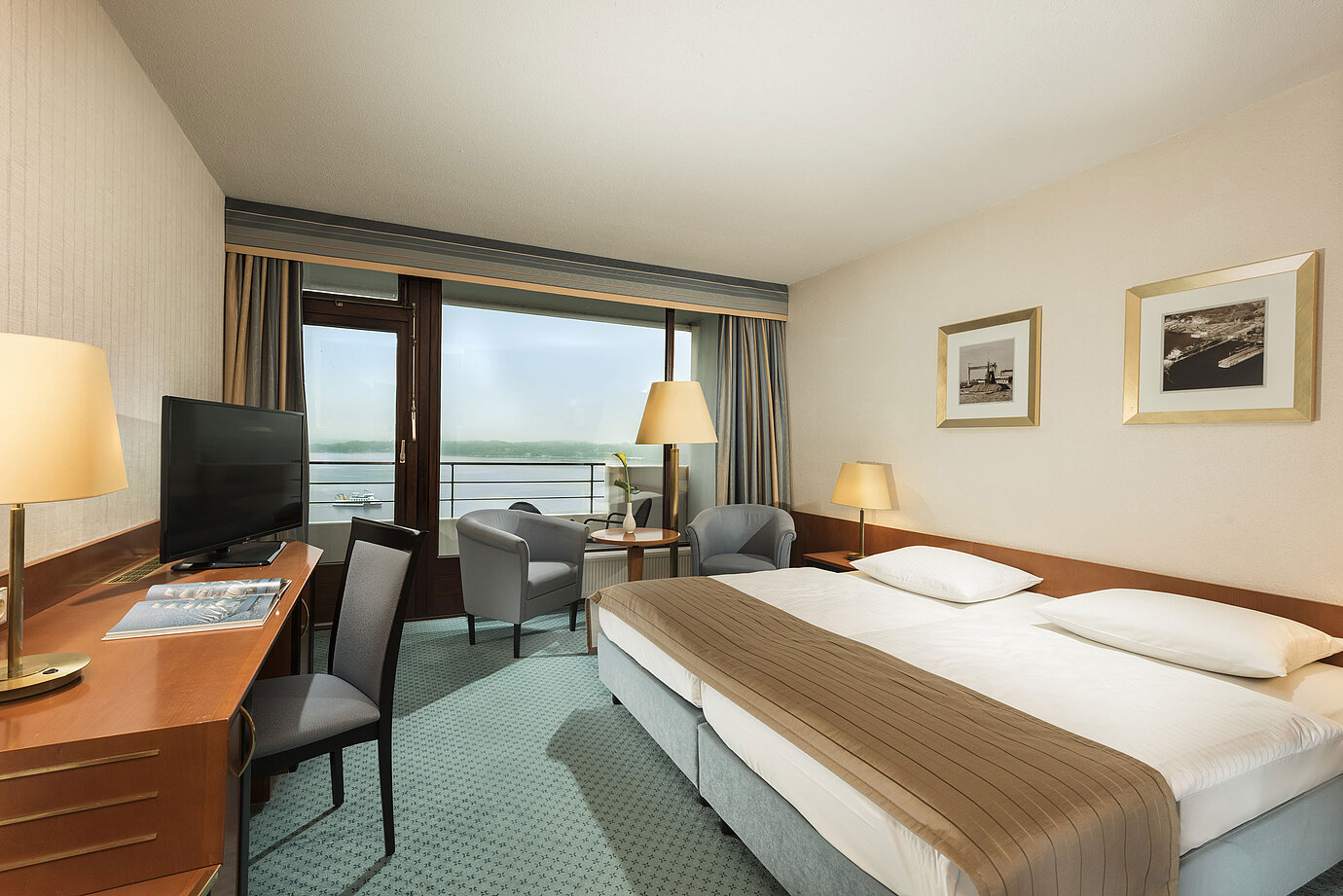 Superior Zimmer im Maritim Hotel Kiel mit Schreibtisch, Sitzbereich, großem Doppelbett und Balkon mit Blick auf die Förde.