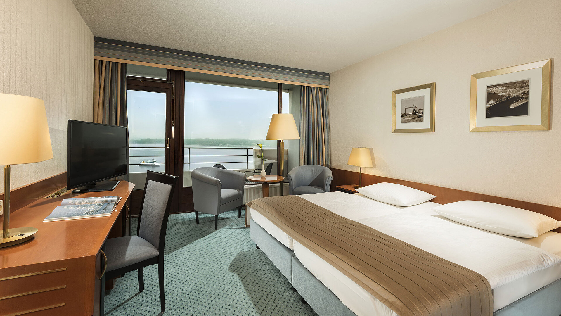 Superior Zimmer im Maritim Hotel Kiel mit Schreibtisch, Sitzbereich, großem Doppelbett und Balkon mit Blick auf die Förde.
