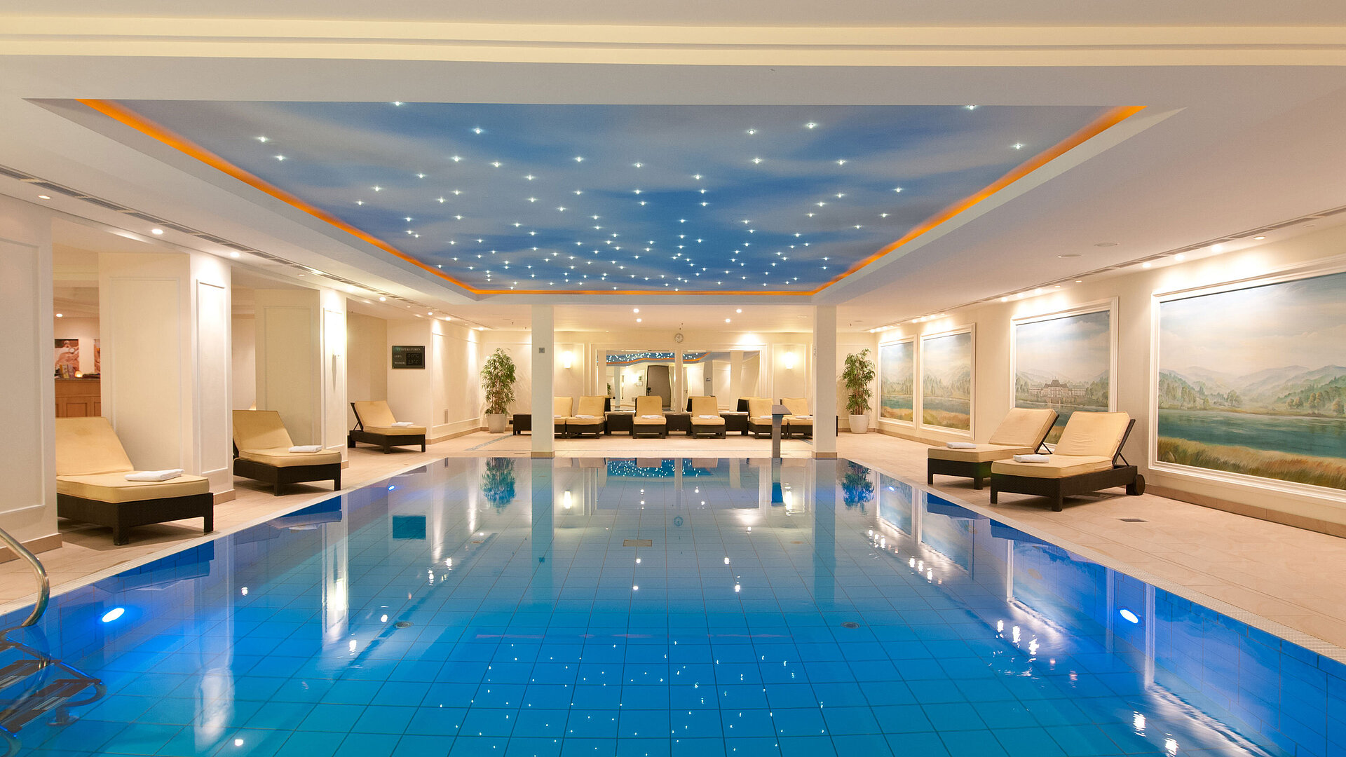 Schwimmbad Luxuriöses Hallenbad im Maritim Hotel Dresden mit Liegen und stimmungsvollem Licht an der Decke.